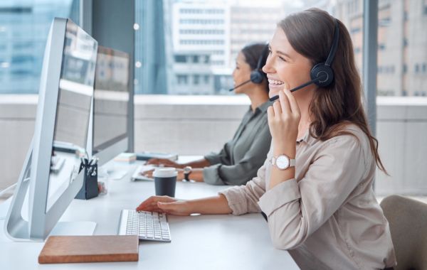 a customer service agent sitting at a desk smiling